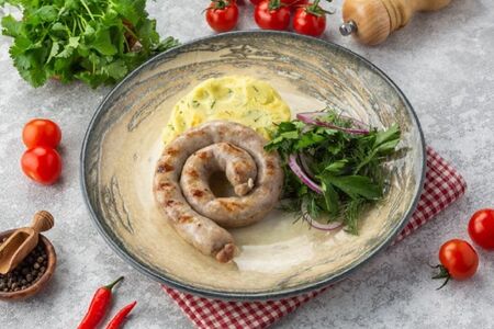 Свиные колбаски с картофельным пюре и зеленью