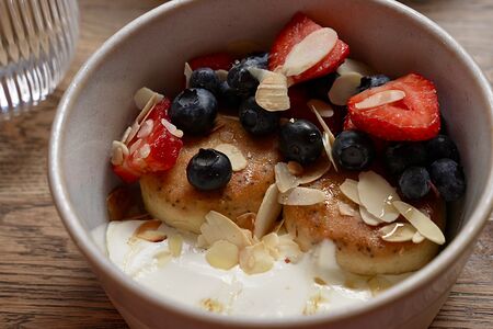 Сырники из топленого творога с маком, лимонной цедрой и сезонными ягодами