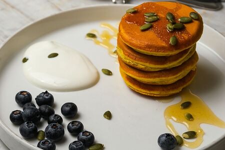 Тыквенные панкейки с медом, сметаной и семечками