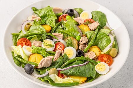 Большой Нисуаз с тунцом, картофелем, перепелиным яйцом, томатами, листьями салата и красным луком