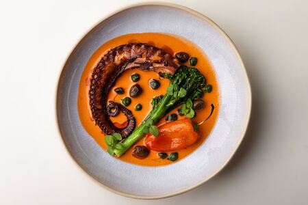 Осьминог с соусом ромеско, брокколини и печеным перцем 