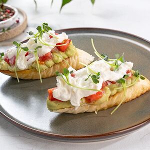 Брускетты с авокадо, страчателлой и розовыми томатами