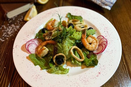 Салат с обжаренным кальмаром, креветкой и вялеными томатами