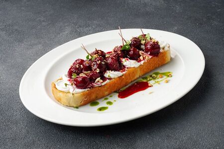 Брускетта с мягким сыром, вялеными томатами и копчёной вишней