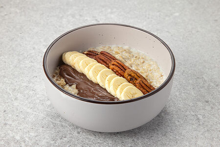 Каша овсяная с шоколадно-ореховой пастой бананом пеканом и голубикой