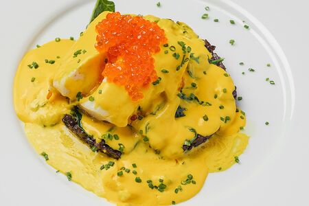 Запеченный палтус с  черным ризотто, шафрановым соусом и красной икрой
