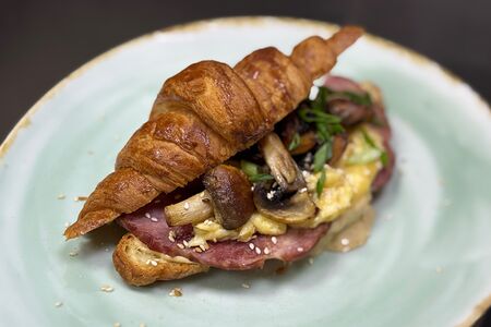 Круассан с окороком, скремблом и грибами в устричном соусе