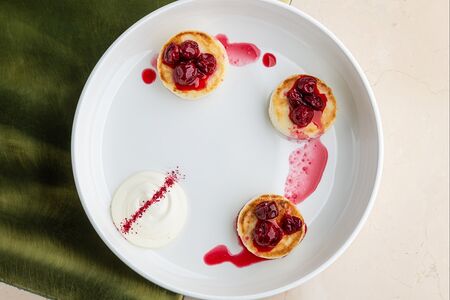 Сырники с вишнёвым соусом и сметаной