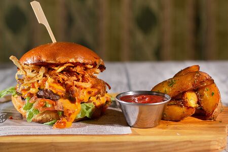 Бургер с горячим соусом чеддер и картофелем по-деревенски