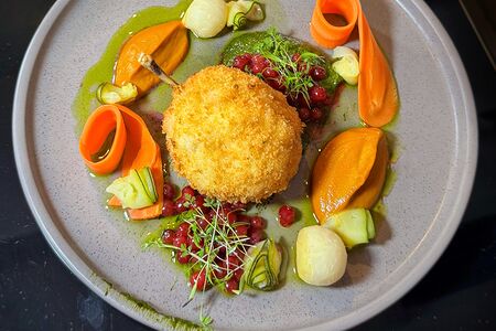 Котлета по-киевски с овощами, морковным кремом, мочёной брусникой и песто из базилика