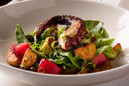 Теплый салат с осьминогом, томатами, молодым картофелем и оливками