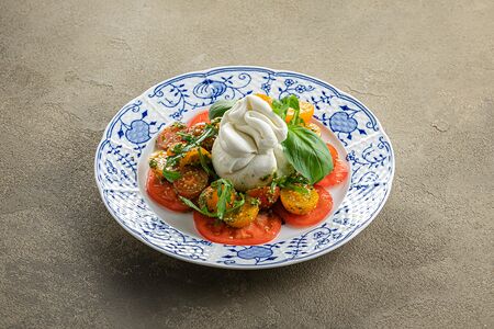 Салат из томатов с бурратой, рукколой и соусом песто