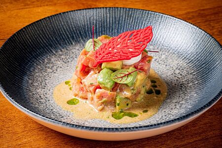 Тартар из тунца с авокадо, сладкими томатами и кунжутной заправкой 