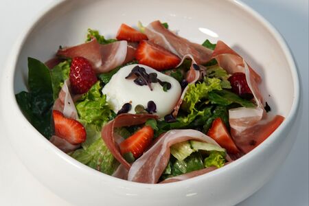 Зеленый салат с сыровяленой уткой, яйцом пашот и ореховым соусом