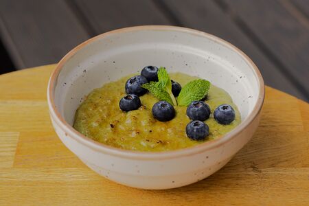 Овсяная каша на молоке с фисташкой и голубикой