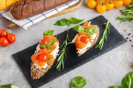 Брускетта с лососем слабой соли, сыром страчателла, томатами и каперсами