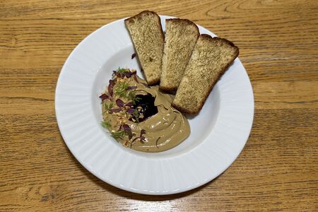 Паштет из потрошков цыплят с подпеченной на углях бриошью, фундуком и соусом из черной смородины