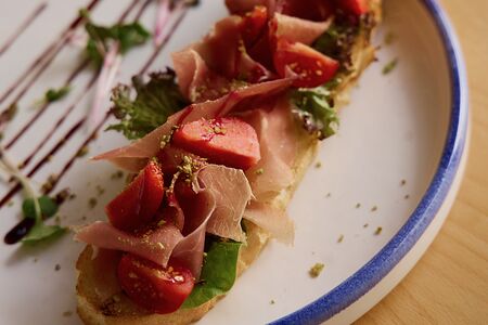 Брускетта с пармой, страчателлой и сезонными ягодами