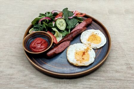 Яичница с говяжьими колбасками и овощным салатом
