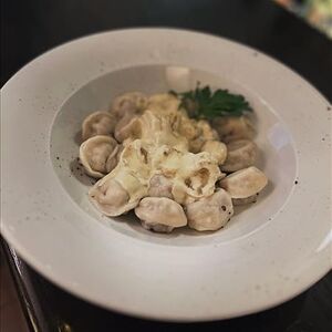 Пельмени охотничьи под соусом из белых грибов