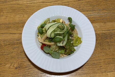 Салат с кальмаром, маринованными томатами черри и перепелиным яйцом