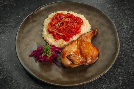 Половина запеченного цыпленка с ризотто и томатами