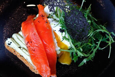 Тост с лососем, кремом из авокадо, руколой и 2 яйцами пашот