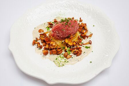 Тартар из говядины картофелем конфи, лисичками и перечным соусом 