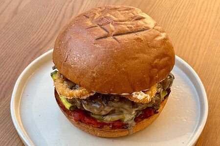 Бургер с говяжьей котлетой, грибным рагу, луком-фри и трюфельным айоли 