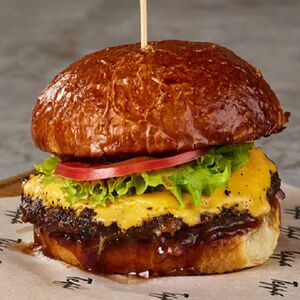 Большой бифбургер с беконом, маринованными огурцами и фирменным соусом барбекю