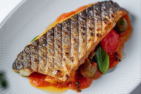 Филе сибаса на гриле со сладкими томатами и артишоками 