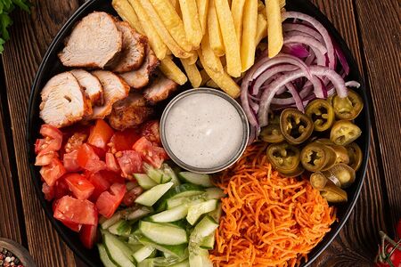 Шаверма на тарелке со свининой и курицей