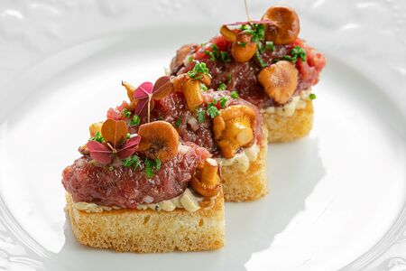 Тартар из мраморной говядины с лисичками на булочке бриошь
