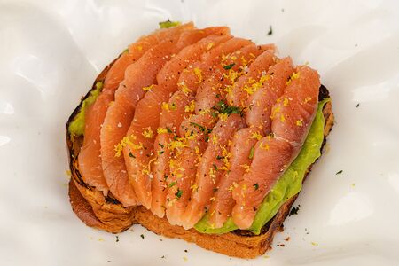 Бриошь со слабосолёной форелью и мятым авокадо 