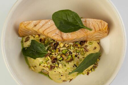 Филе лосося с кремом из цветной капусты, листьями шпината и фисташкой