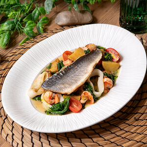 Филе сибаса с обжаренным картофелем, шпинатом и морепродуктами