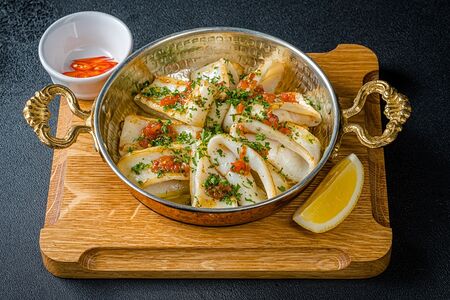 Нежные кальмары на сковороде с томатами в чесночном соусе