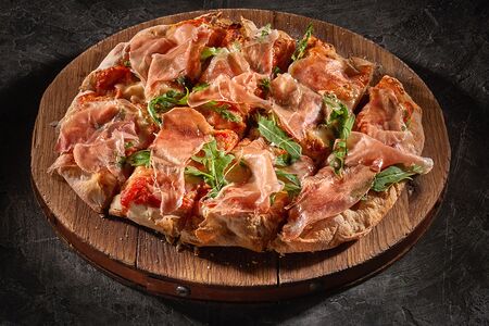 Пицца Пармский окорок, вяленые томаты и рукола