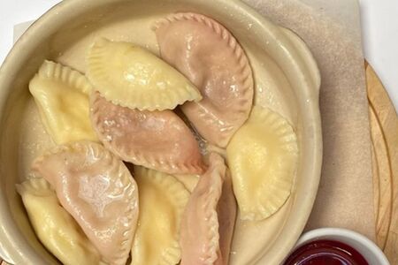 Ассорти из сладких вареников с вишневым топпингом