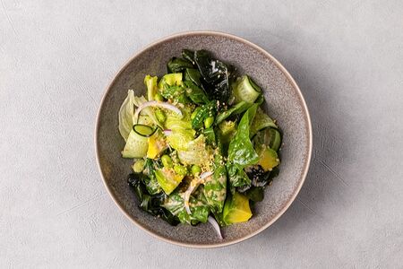 Зелёный салат с авокадо, эдамаме, огурцом, вакаме и ореховым соусом