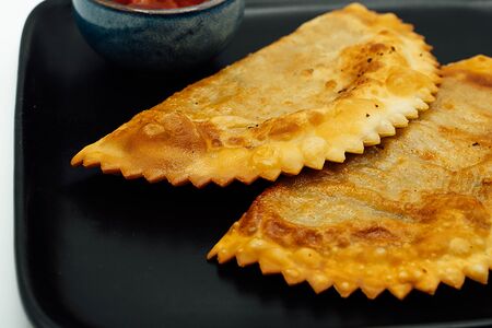 Пара чебуреков с соусом сацебели