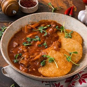 Драники с мясной поджаркой из свинины и томатным соусом 