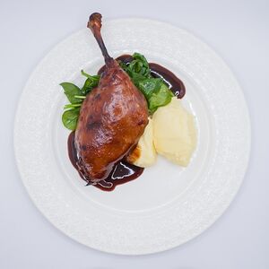Утиная ножка на подушке из шпината с картофельным пюре