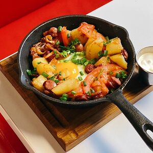 Жареная картошка с грудинкой, колбасками и глазуньей
