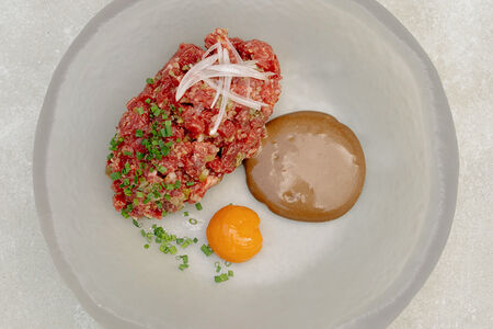 Тартар из говядины с соусом из черного чеснока и желтком конфи
