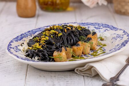 Паста Неро с гребешком и фисташками 