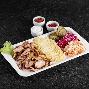 Шаурма на тарелке c гарниром, салатом и соусами