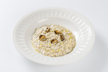 Ризотто с трюфельным соусом, приготовленное в сырной головке грана падано