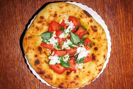 Лепешка с томатами, песто и страчателлой