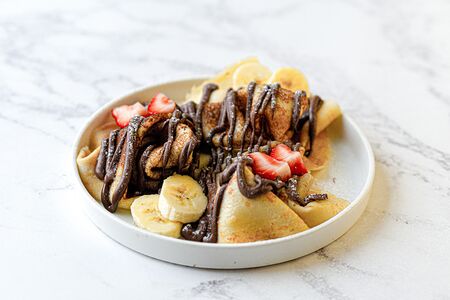 Блинчики с шоколадной пастой, клубникой и бананом